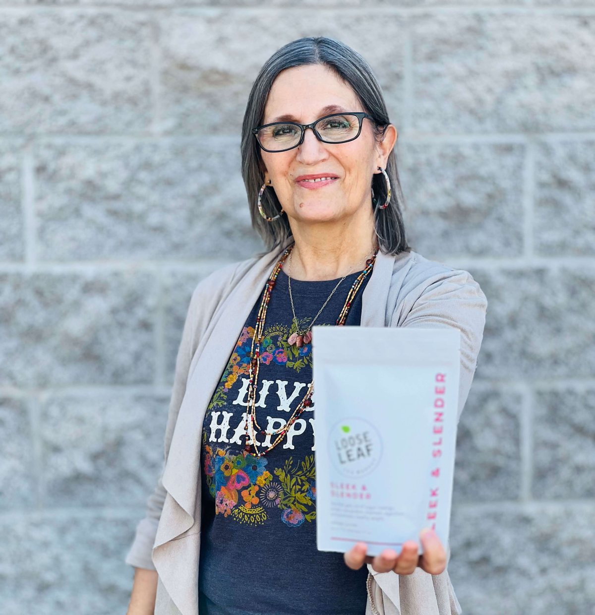 Kita Centella, founder of Loose Leaf Tea Market, holding a pouch of Sleek & Slender Tea