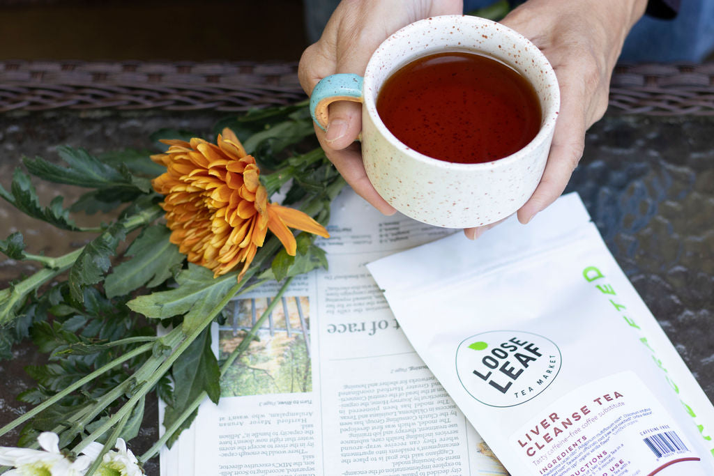 Person holding a cup of Liver Cleanse Tea.